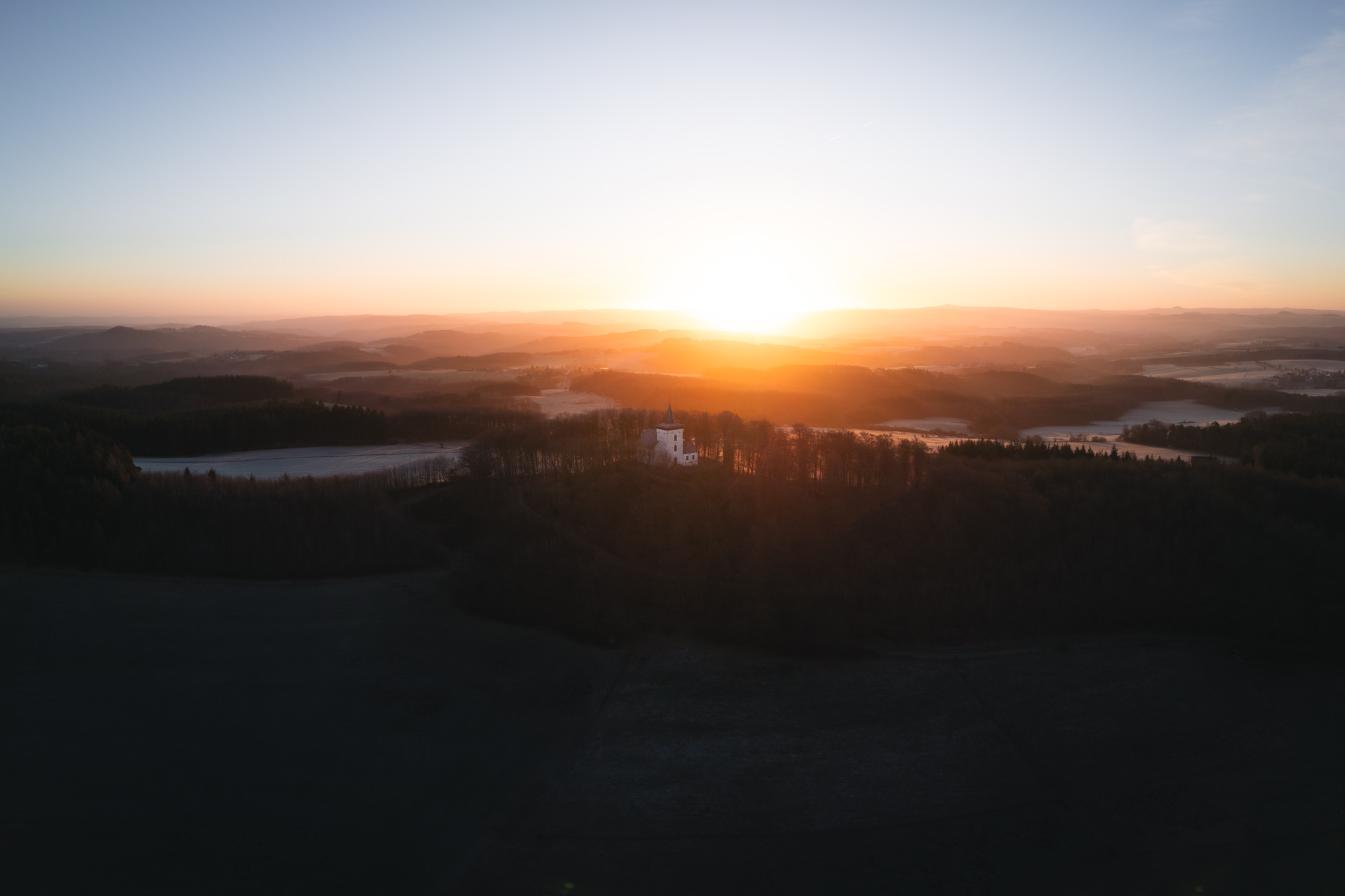Eifelblick Michelsberg Sonnenaufgang hinter der Kapelle St. Michael im Winter