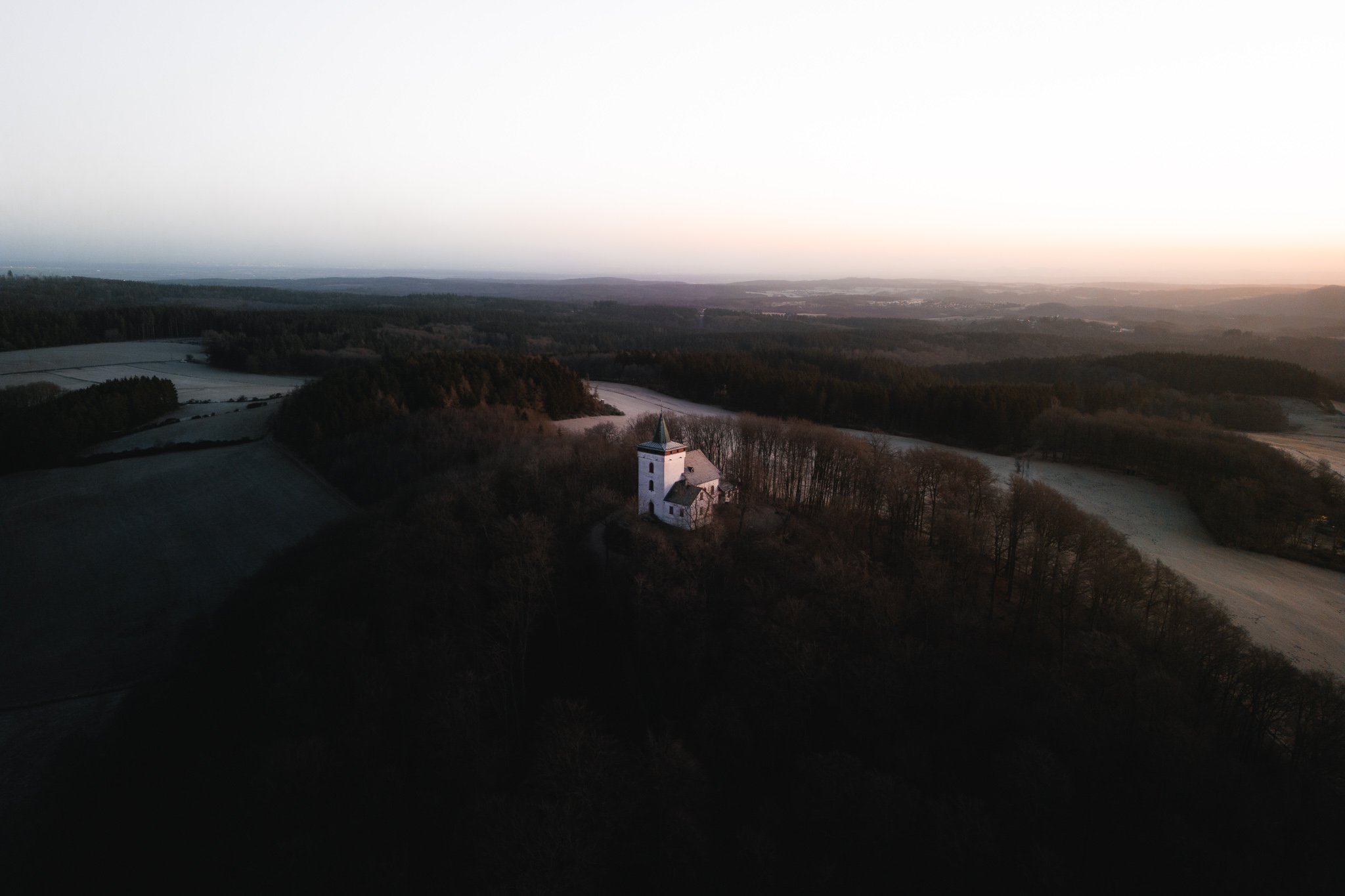 Eifelblick Michelsberg Sonnenaufgang hinter der Kapelle St. Michael im Winter